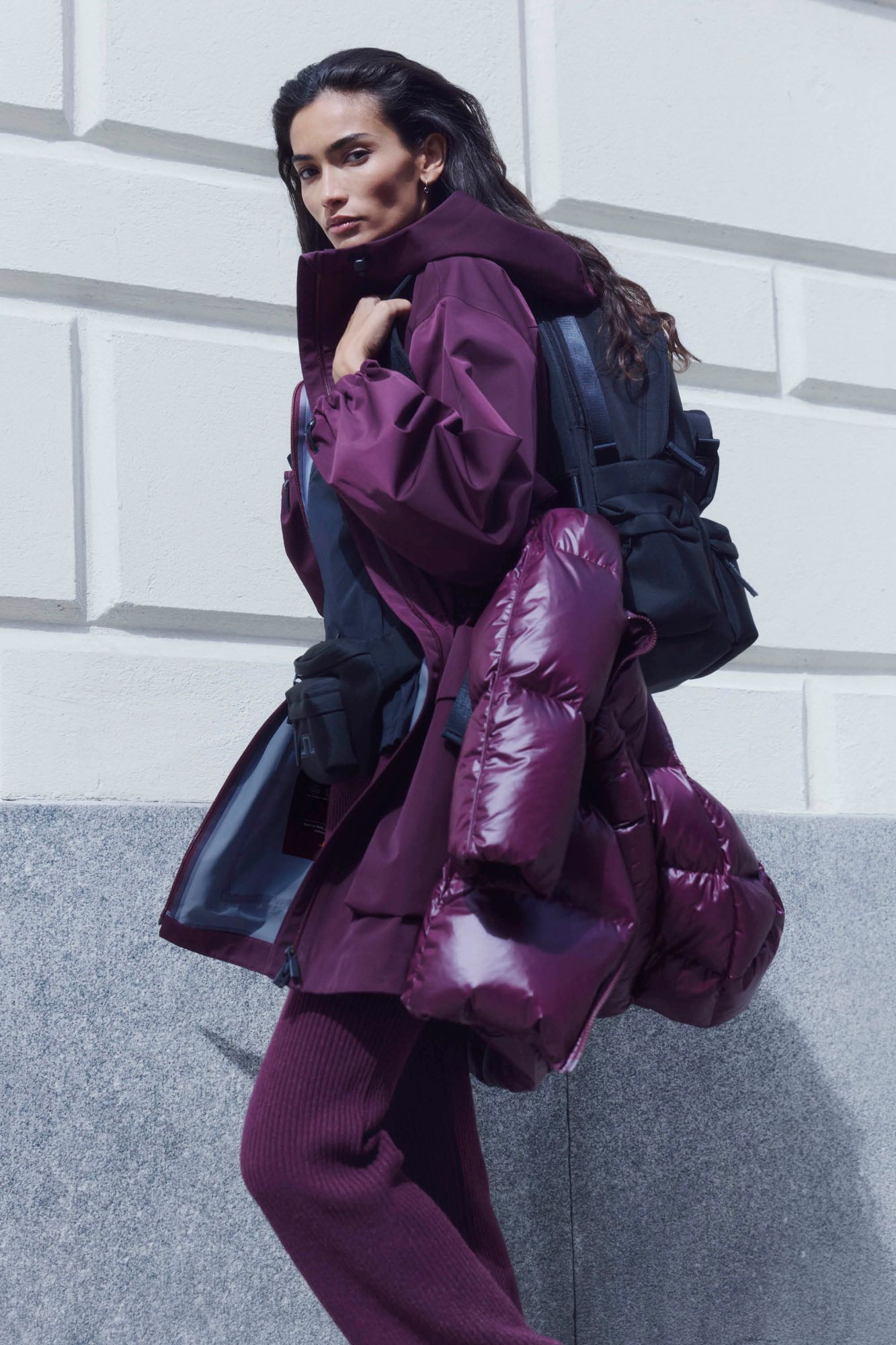 Kelly Gale in a plum parka carrying a puffer jacket