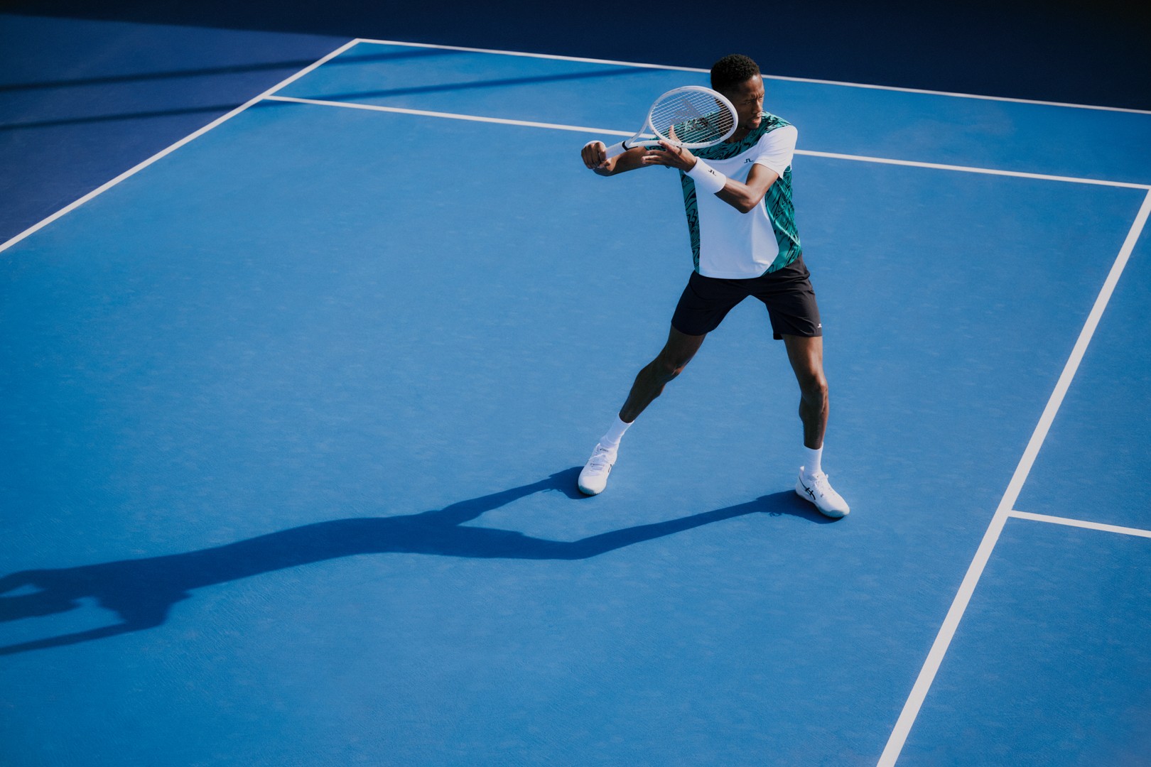 Tennis player hitting a backhand on a blue court